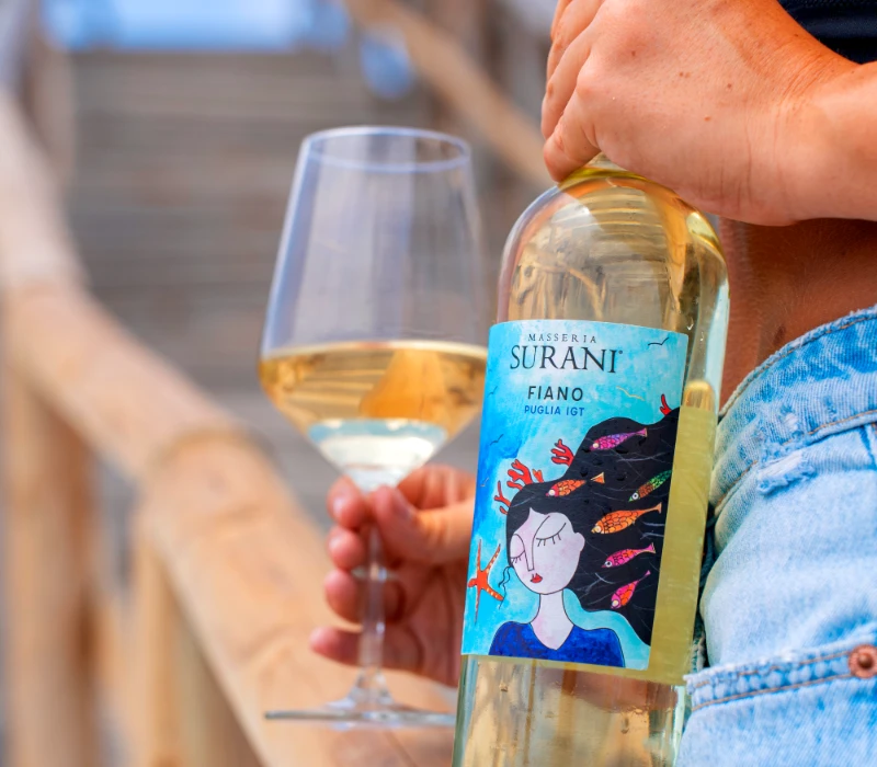 Bottiglia di Fiano Puglia IGT Surani con calice durante degustazione
