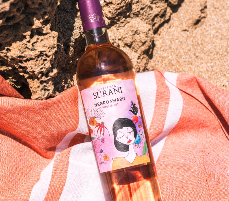 Bottiglia di Negroamaro rosé Surani in ambientazione mediterranea
